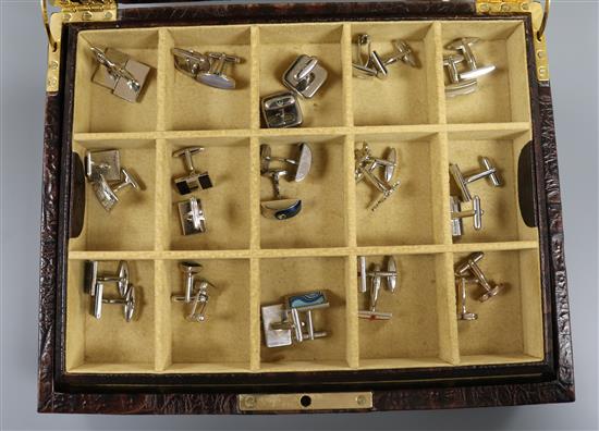 A Daines & Hathaway brown crocodile hide cufflink case containing 24 pairs of cufflinks, tie clips and money clips, etc.